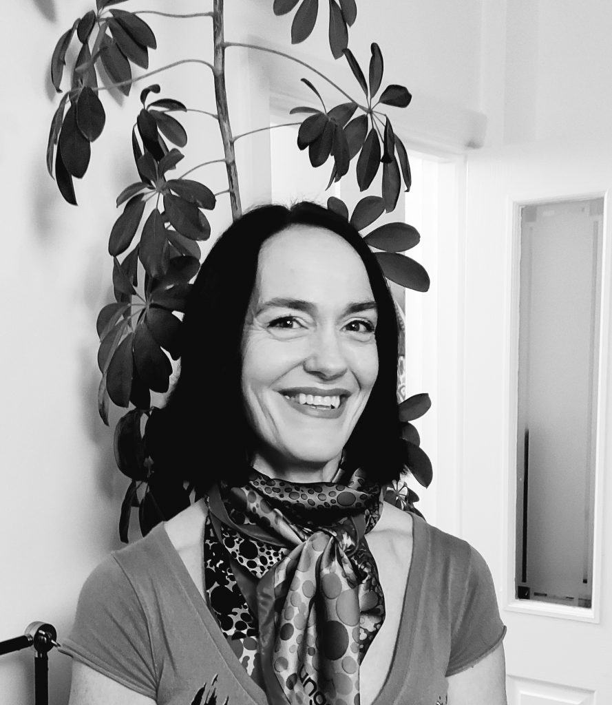 A black and white photograph of Tatiana Egeler counsellor in Sussex smiling in her office in Portslade